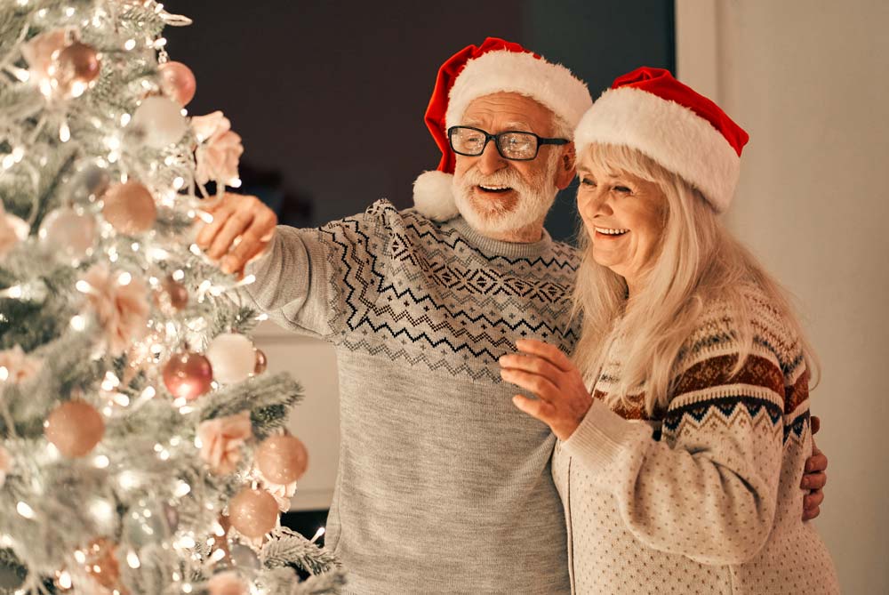 happy senior couple decorating christmas tree