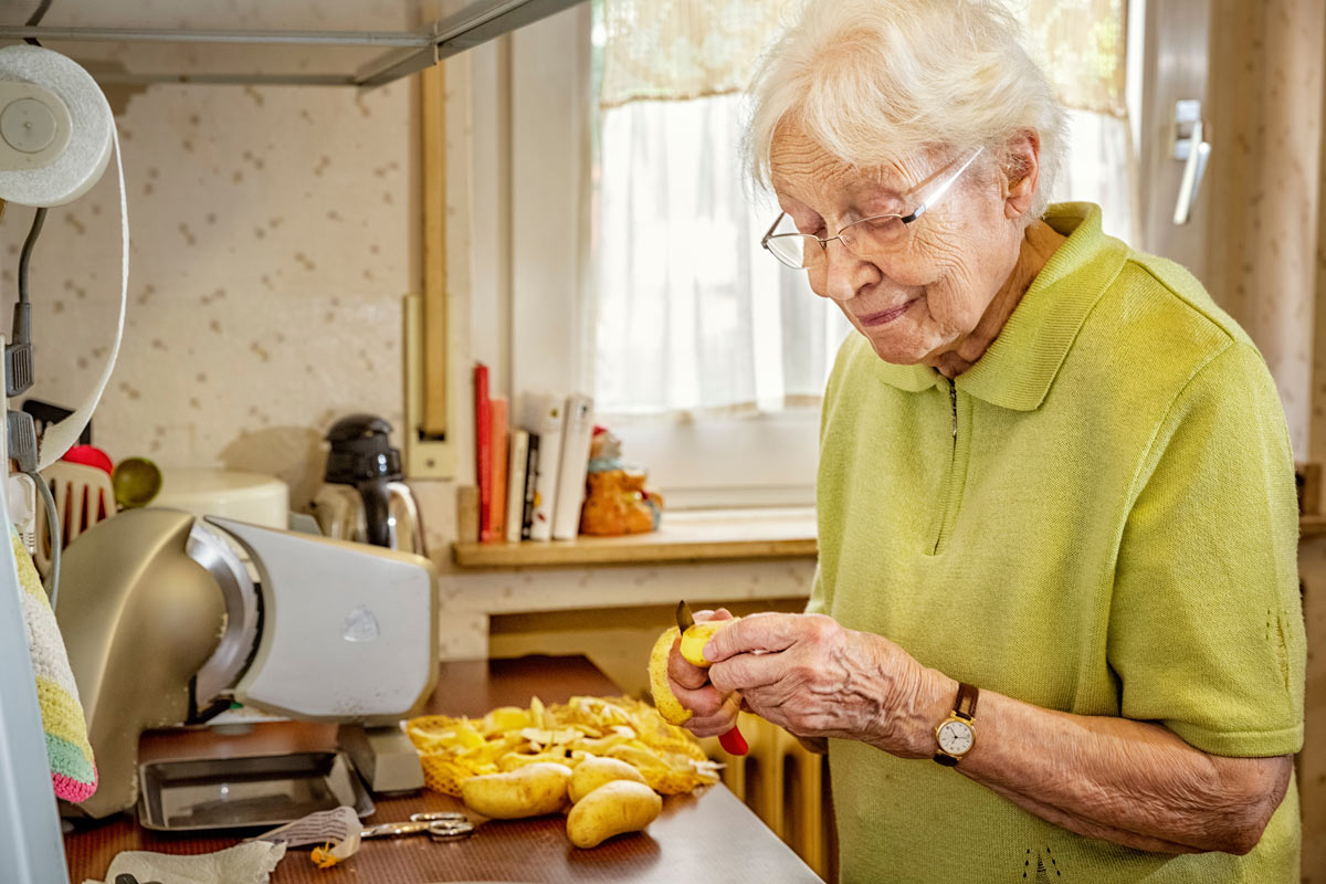 VRS Pacific Carlton Senior peeling potatoes for cooking in assisted living suite