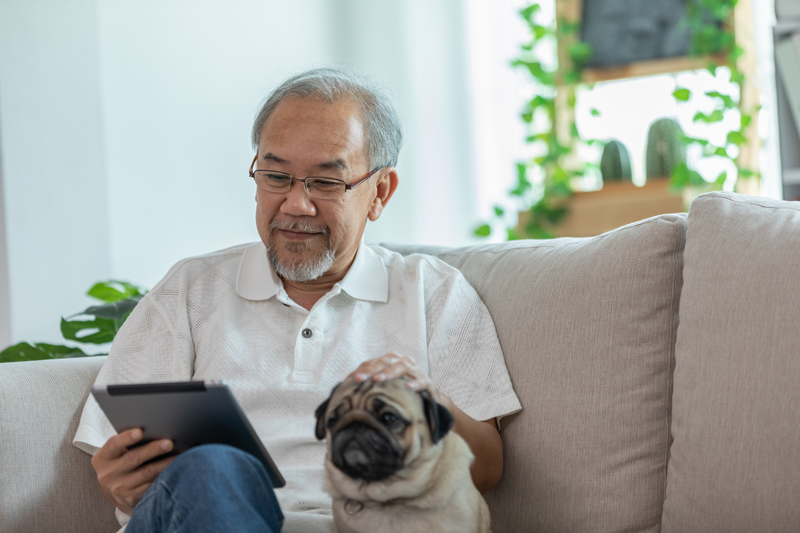 Senior on iPad tablet with dog at VRS retirement home in South Surrey White Rock